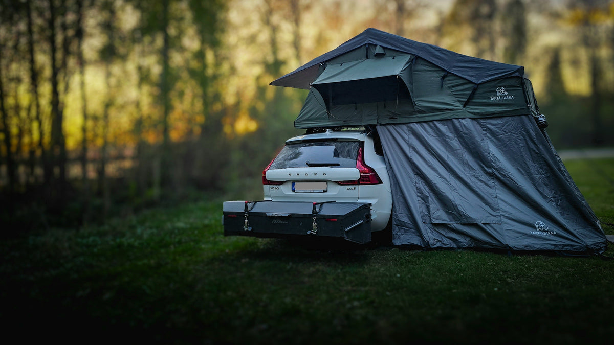 Auto met een IXTAbox op de trekhaak en een daktent, ingepakt voor een gezinsreis